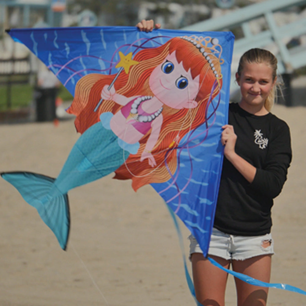 girl holding mermaid kite at the beach