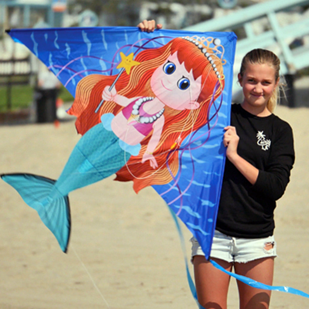 girl holding mermaid kite at the beach
