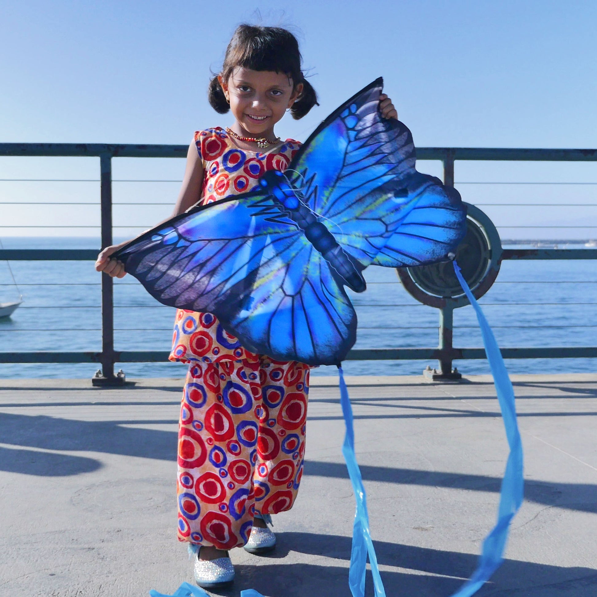 girl holding blue butterfly kite 