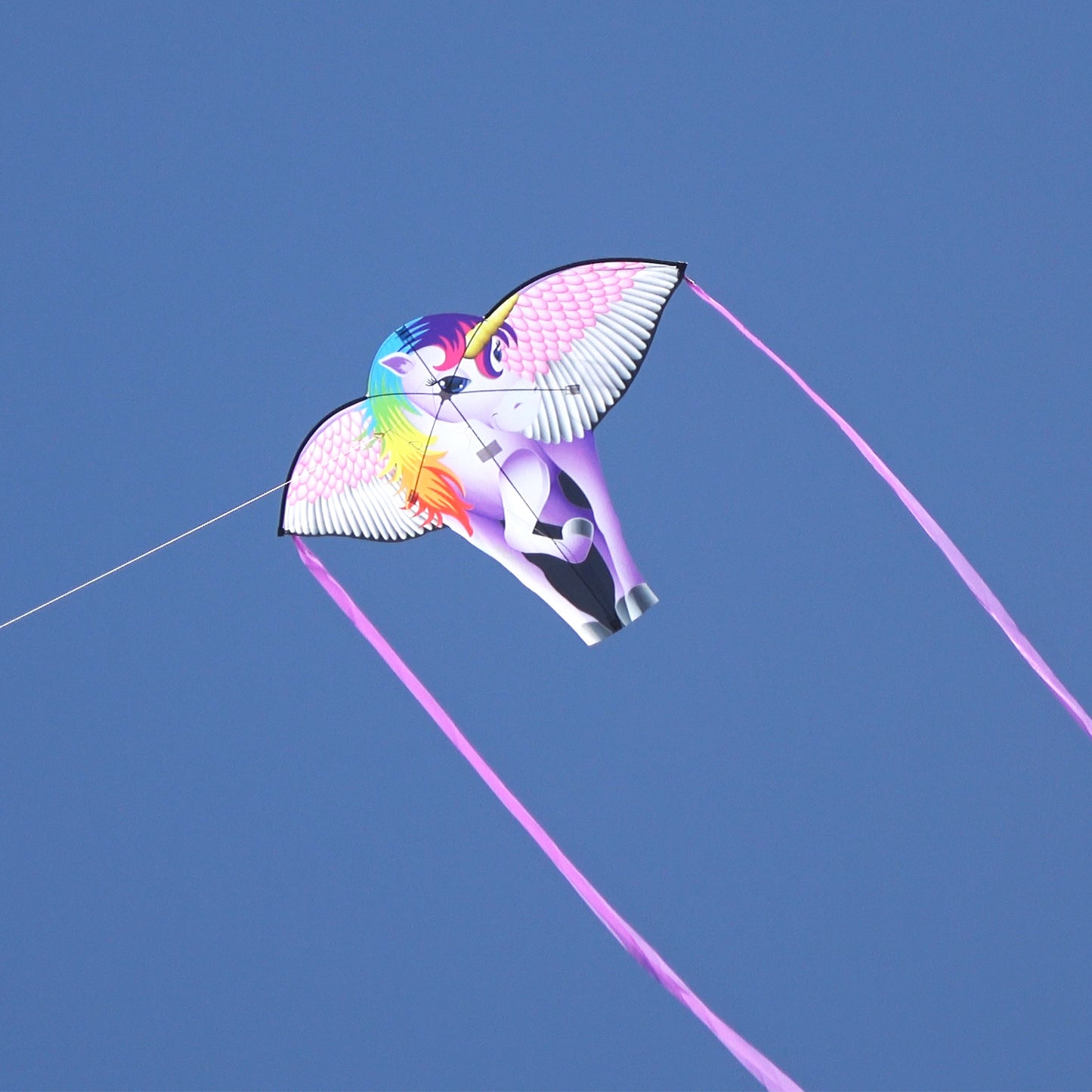 A photo of a WindNSun SuperSize Ultra Unicorn Ripstop Nylon Unicorn Kite Flying taken from the ground