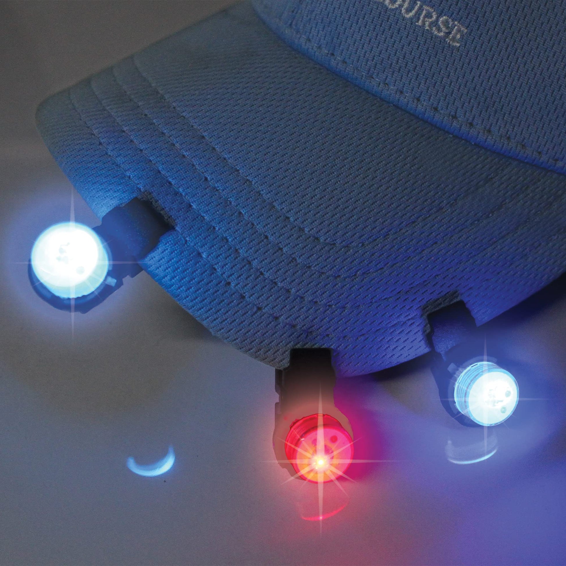 A photo of a light blue hat on a white background in the dark with three WindNSun UFO Mini Lights flashing red and blue cliped along the bill