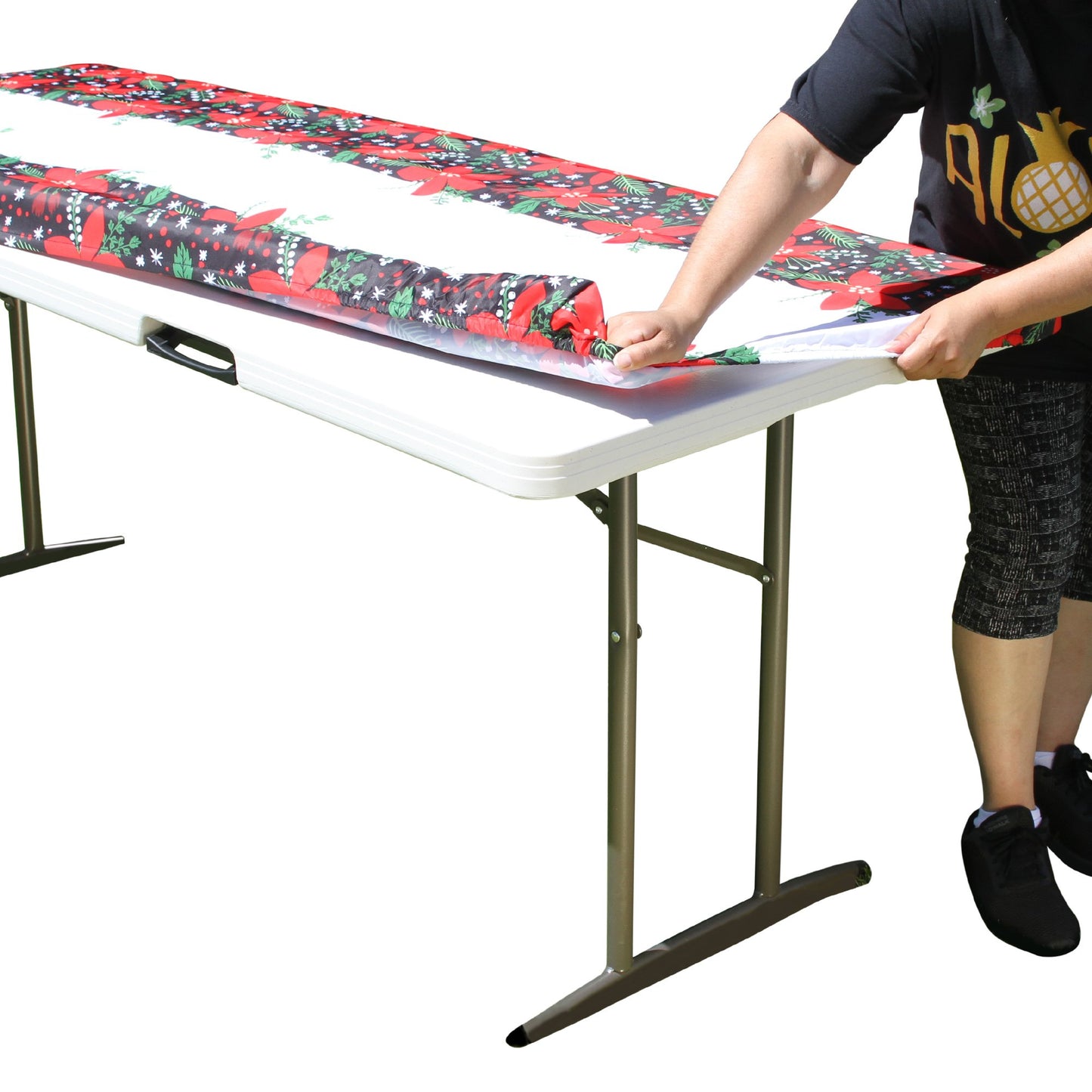 A person stretching TableCloth PLUS 72" Winter Fitted Polyester Tablecloth for 6' Folding Tables over a folding table