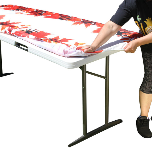 A person stretching TableCloth PLUS 72" Fall Fitted Polyester Tablecloth for 6' Folding Tables over a folding table